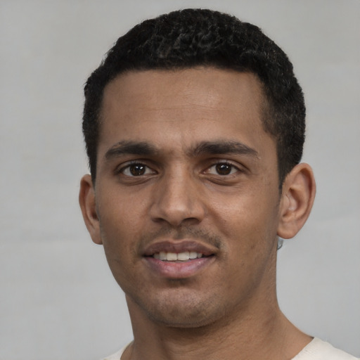 Joyful black young-adult male with short  black hair and brown eyes