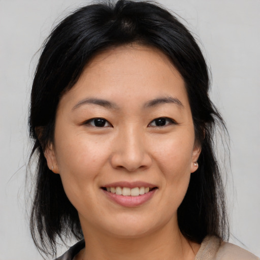 Joyful asian young-adult female with medium  brown hair and brown eyes