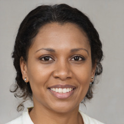 Joyful latino adult female with medium  brown hair and brown eyes