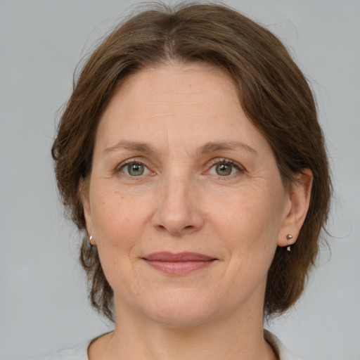 Joyful white adult female with medium  brown hair and grey eyes