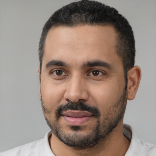 Joyful black young-adult male with short  black hair and brown eyes