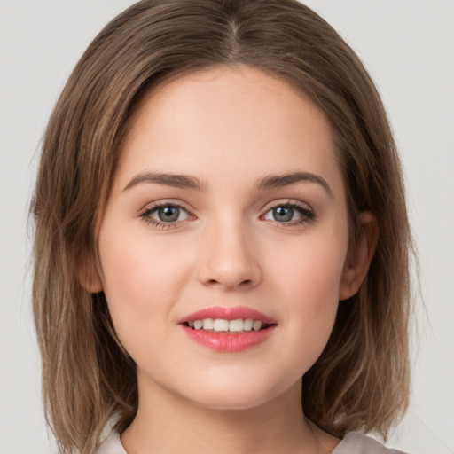 Joyful white young-adult female with medium  brown hair and grey eyes