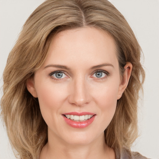 Joyful white young-adult female with long  brown hair and blue eyes