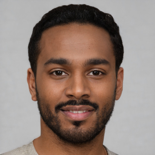 Joyful black young-adult male with short  black hair and brown eyes