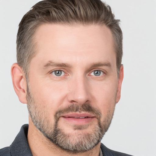 Joyful white adult male with short  brown hair and grey eyes