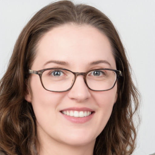 Joyful white young-adult female with long  brown hair and blue eyes