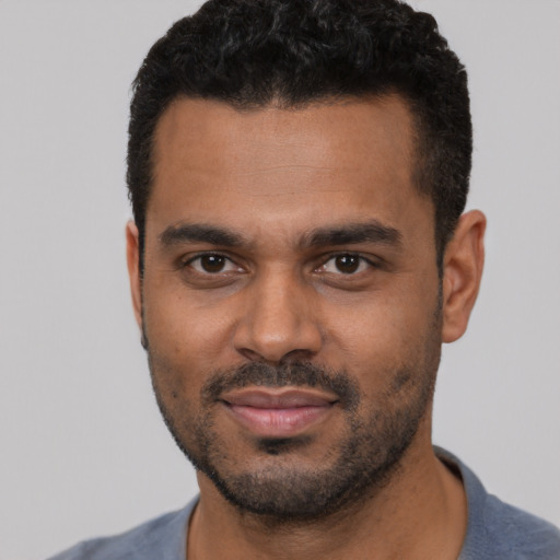 Joyful black young-adult male with short  black hair and brown eyes
