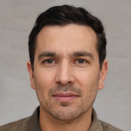 Joyful white adult male with short  black hair and brown eyes