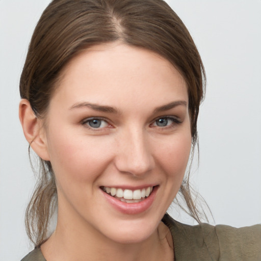 Joyful white young-adult female with medium  brown hair and grey eyes