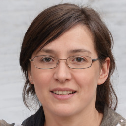 Joyful white adult female with medium  brown hair and grey eyes