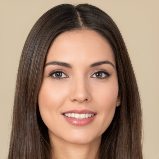 Joyful white young-adult female with long  brown hair and brown eyes