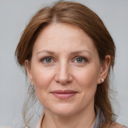 Joyful white adult female with medium  brown hair and grey eyes