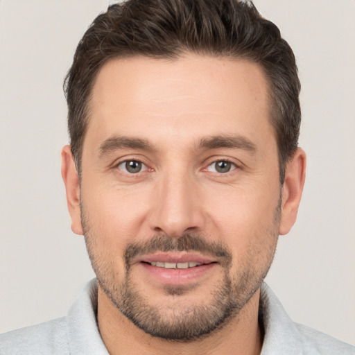 Joyful white adult male with short  brown hair and brown eyes