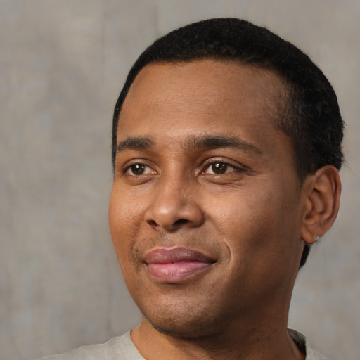 Joyful black young-adult male with short  black hair and brown eyes