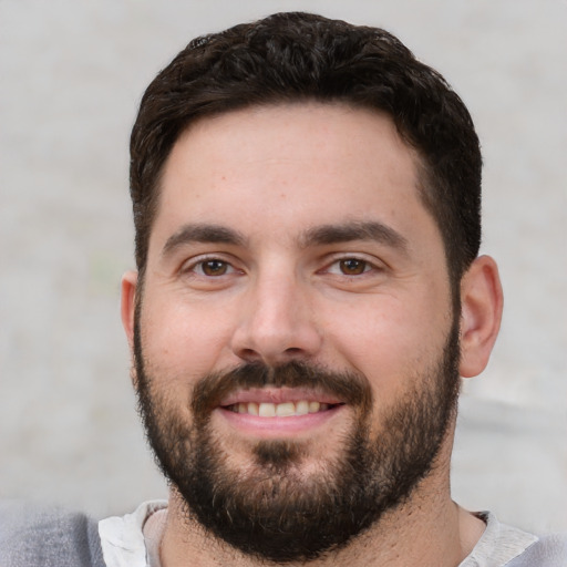 Joyful white young-adult male with short  black hair and brown eyes