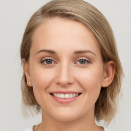 Joyful white young-adult female with medium  brown hair and blue eyes