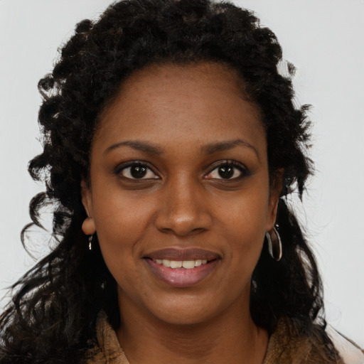 Joyful black young-adult female with long  black hair and brown eyes