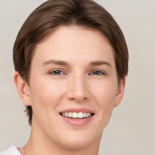 Joyful white young-adult female with short  brown hair and grey eyes