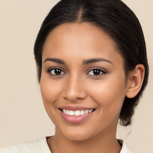 Joyful latino young-adult female with medium  brown hair and brown eyes