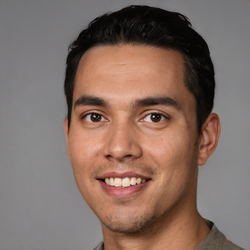 Joyful white young-adult male with short  black hair and brown eyes