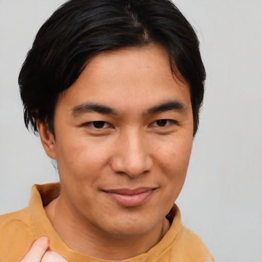 Joyful asian young-adult male with short  brown hair and brown eyes