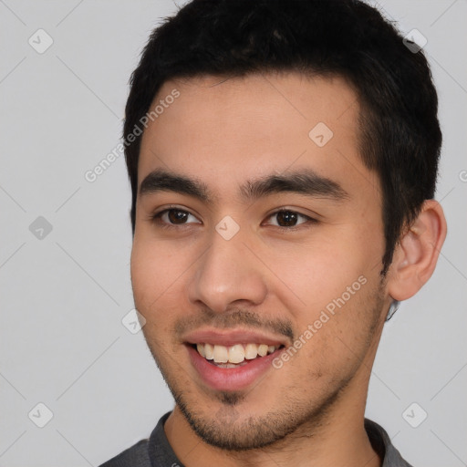 Joyful latino young-adult male with short  black hair and brown eyes