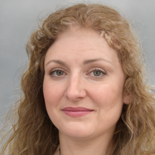 Joyful white adult female with long  brown hair and green eyes