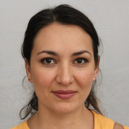 Joyful white adult female with medium  brown hair and brown eyes