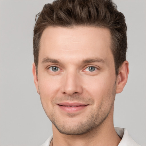 Joyful white young-adult male with short  brown hair and grey eyes