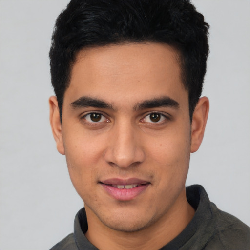 Joyful latino young-adult male with short  black hair and brown eyes