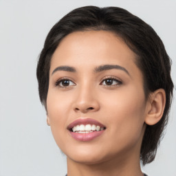 Joyful latino young-adult female with medium  brown hair and brown eyes