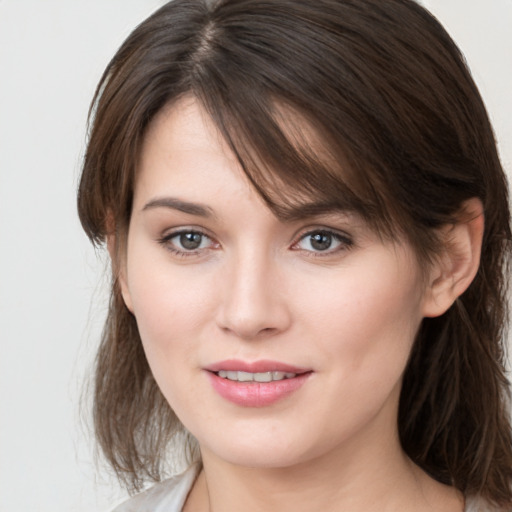 Joyful white young-adult female with medium  brown hair and grey eyes