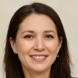 Joyful white adult female with long  brown hair and brown eyes