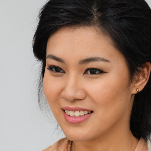 Joyful asian young-adult female with long  brown hair and brown eyes