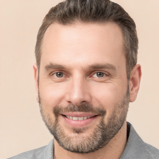 Joyful white adult male with short  brown hair and brown eyes