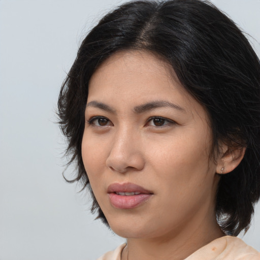 Joyful asian young-adult female with medium  brown hair and brown eyes