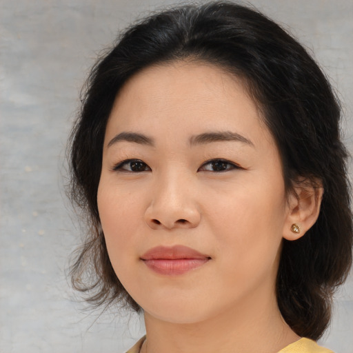 Joyful asian young-adult female with medium  brown hair and brown eyes