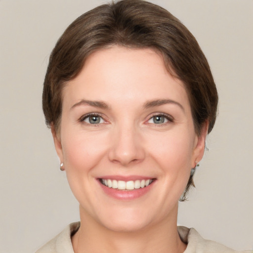 Joyful white young-adult female with short  brown hair and grey eyes