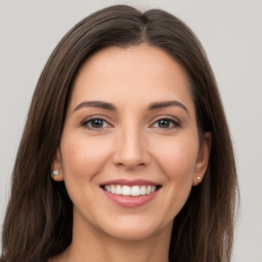 Joyful white young-adult female with long  brown hair and brown eyes