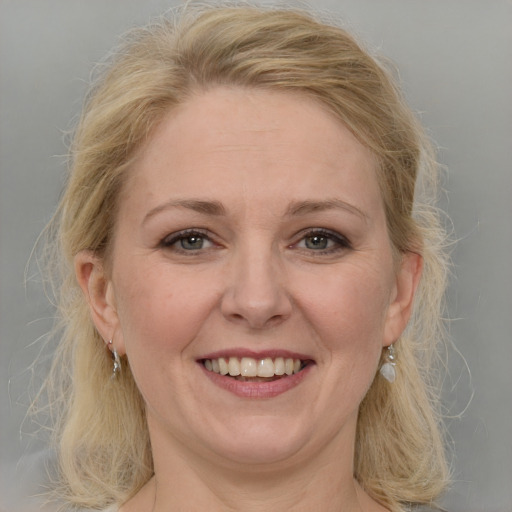 Joyful white adult female with medium  brown hair and blue eyes