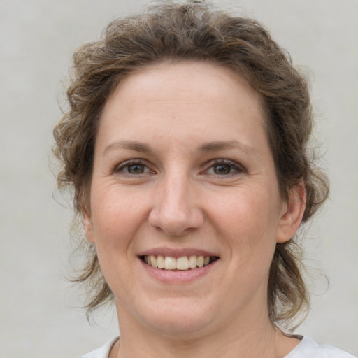 Joyful white adult female with medium  brown hair and grey eyes