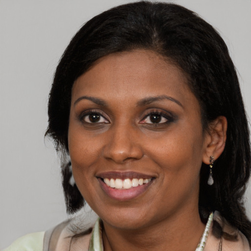 Joyful black young-adult female with medium  brown hair and brown eyes