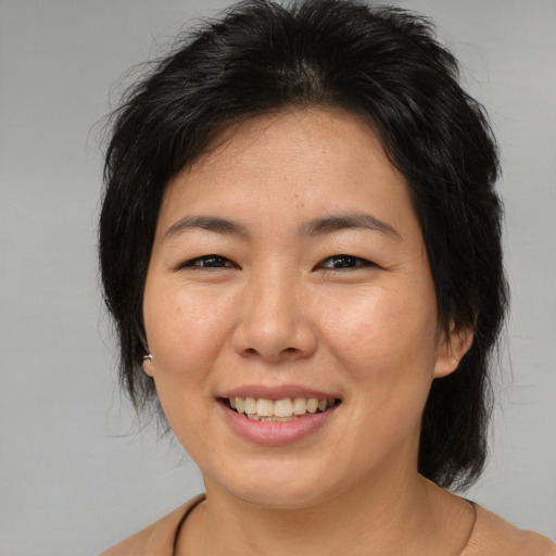 Joyful asian adult female with medium  brown hair and brown eyes