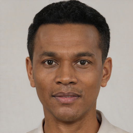 Joyful black young-adult male with short  black hair and brown eyes