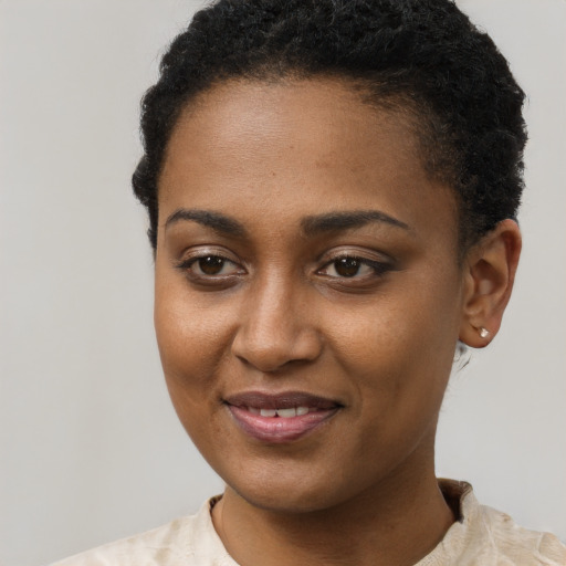 Joyful black young-adult female with short  black hair and brown eyes