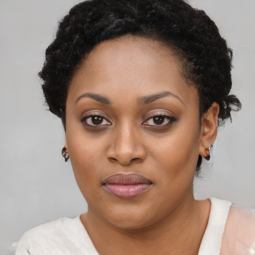 Joyful black young-adult female with short  black hair and brown eyes