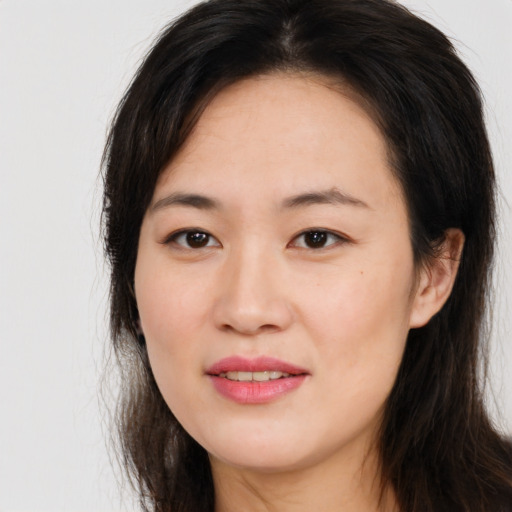 Joyful asian young-adult female with long  brown hair and brown eyes