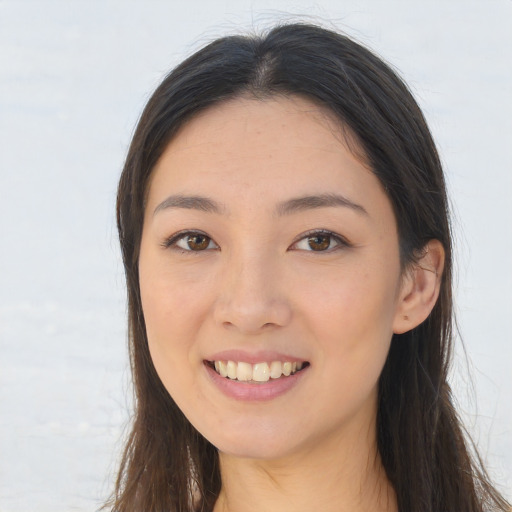 Joyful asian young-adult female with long  brown hair and brown eyes