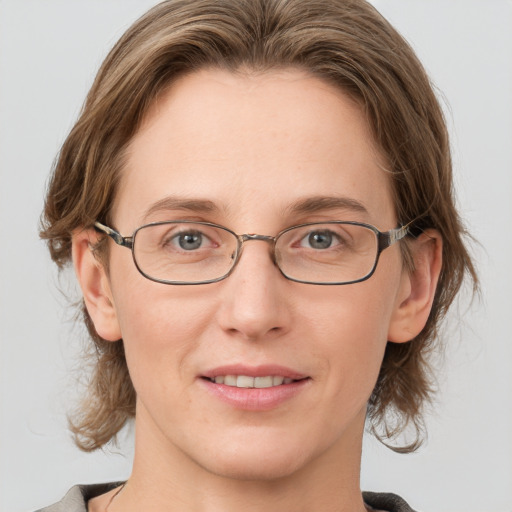 Joyful white adult female with medium  brown hair and grey eyes