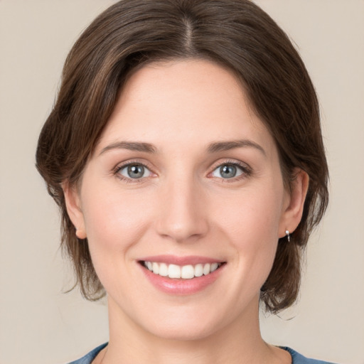 Joyful white young-adult female with medium  brown hair and green eyes